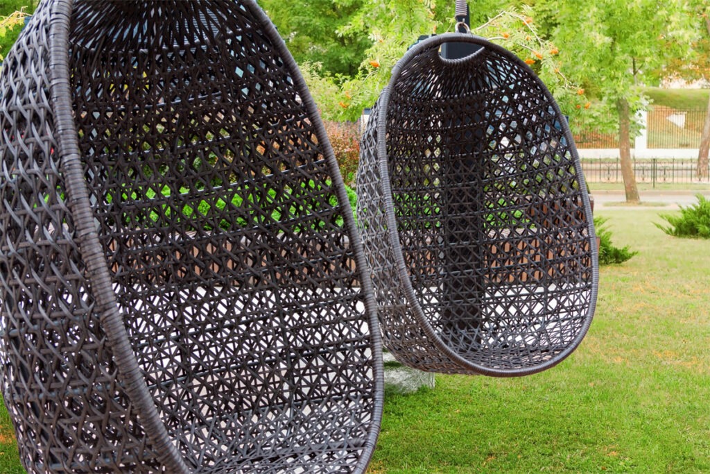 Zwei Hängekorbstühle aus Rattan im Garten