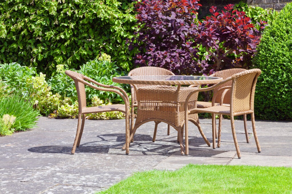 Tisch mit vier Stühlen aus Rattan stehen im Freien